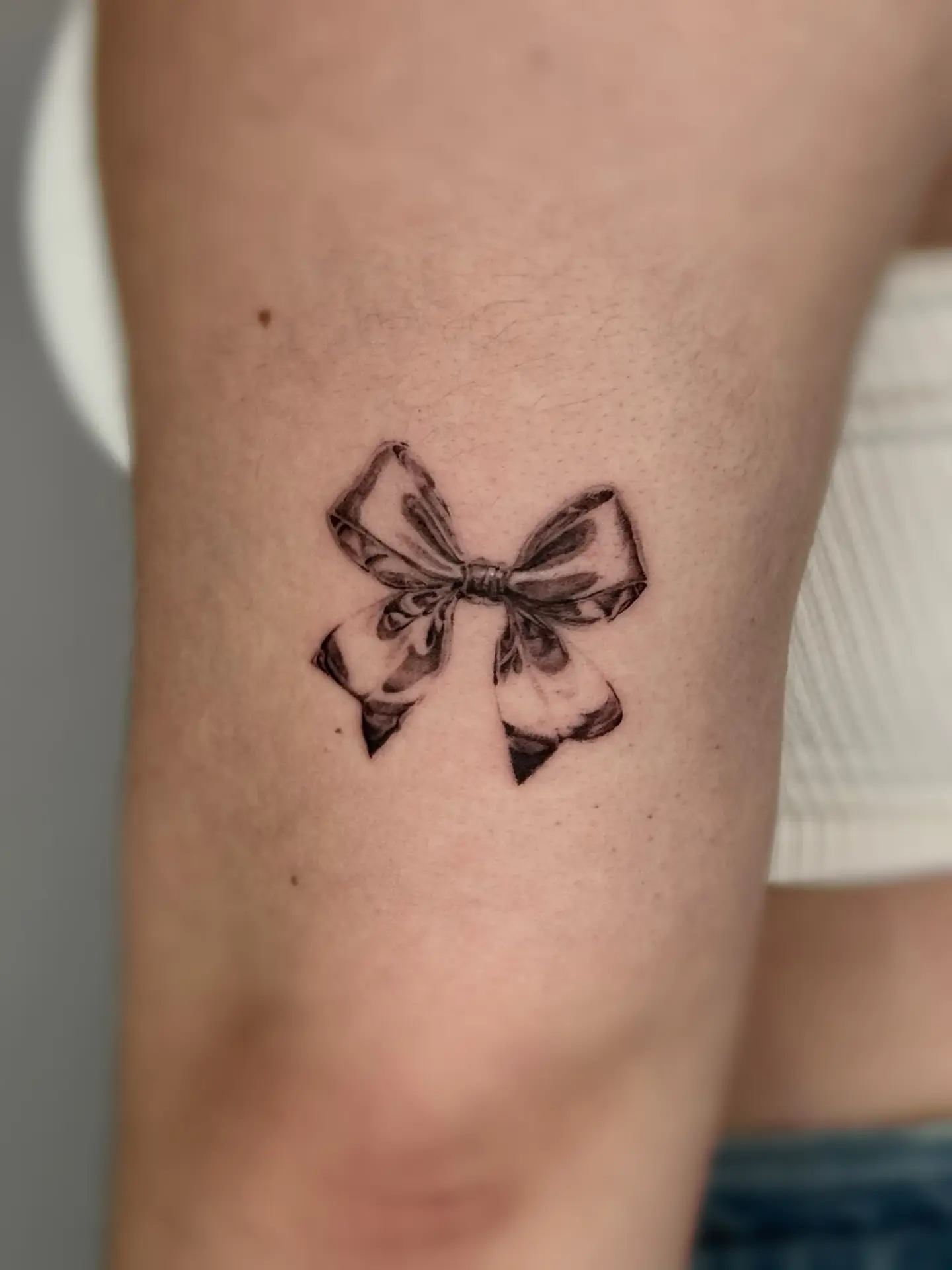 Delicate bow tattoo for a charming look