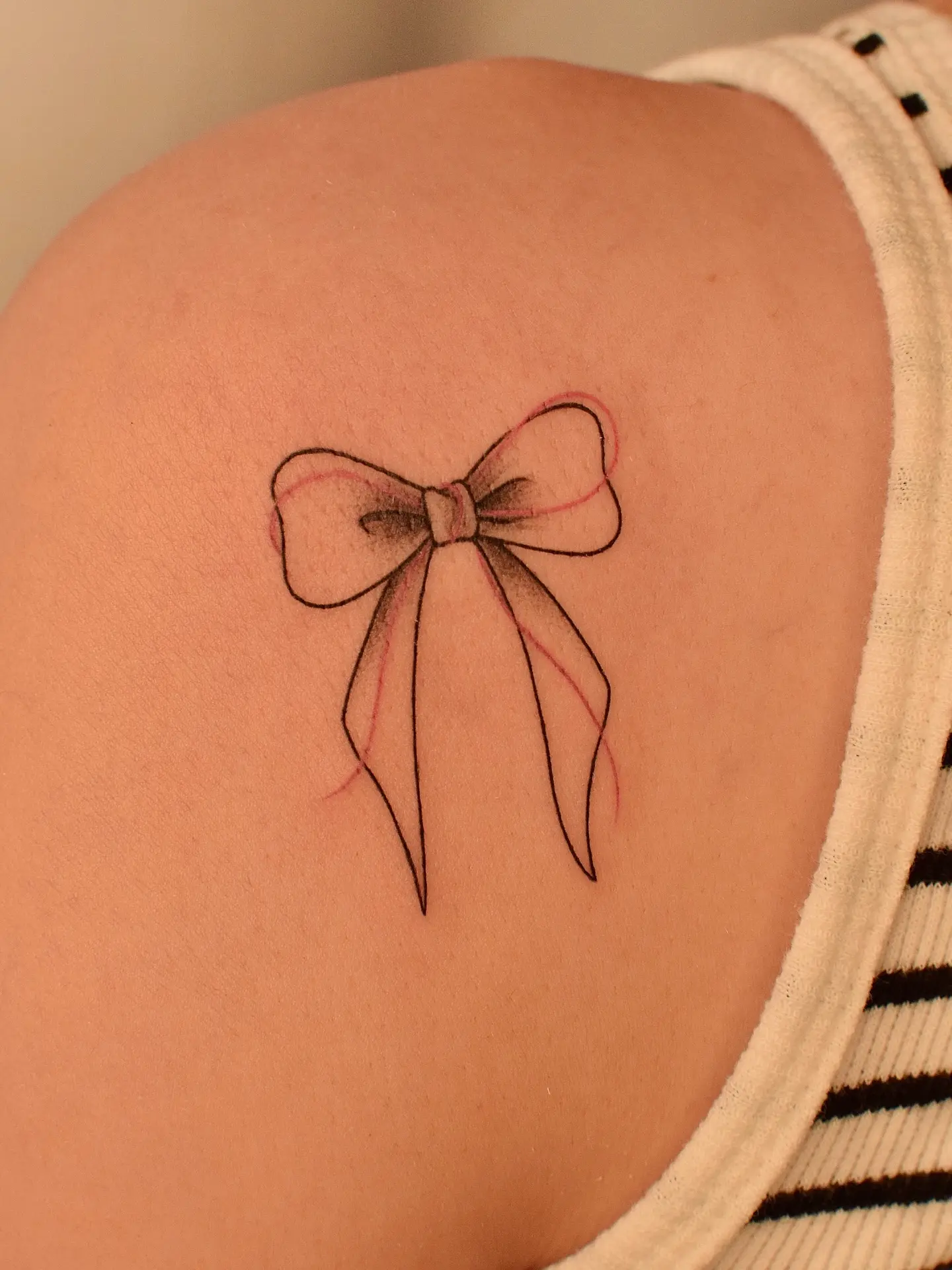 Elegant bow tattoo on shoulder