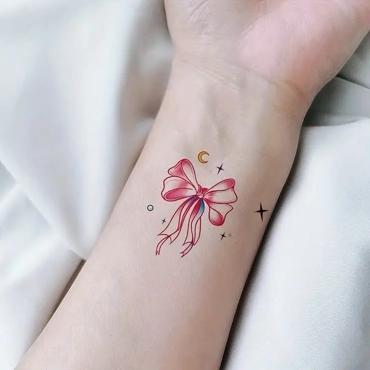 Charming bow tattoo adorned with celestial elements