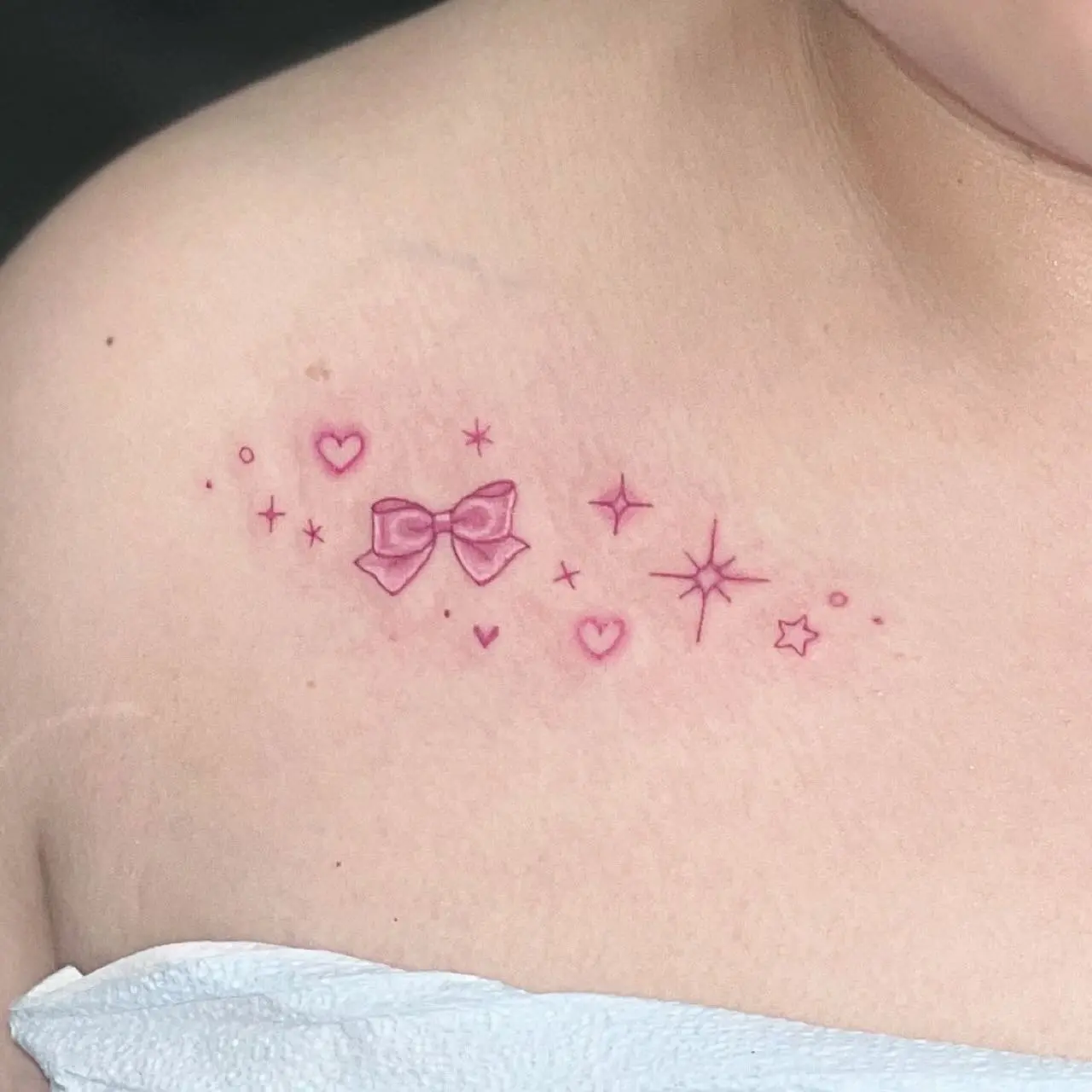 Whimsical bow tattoo with stars and hearts