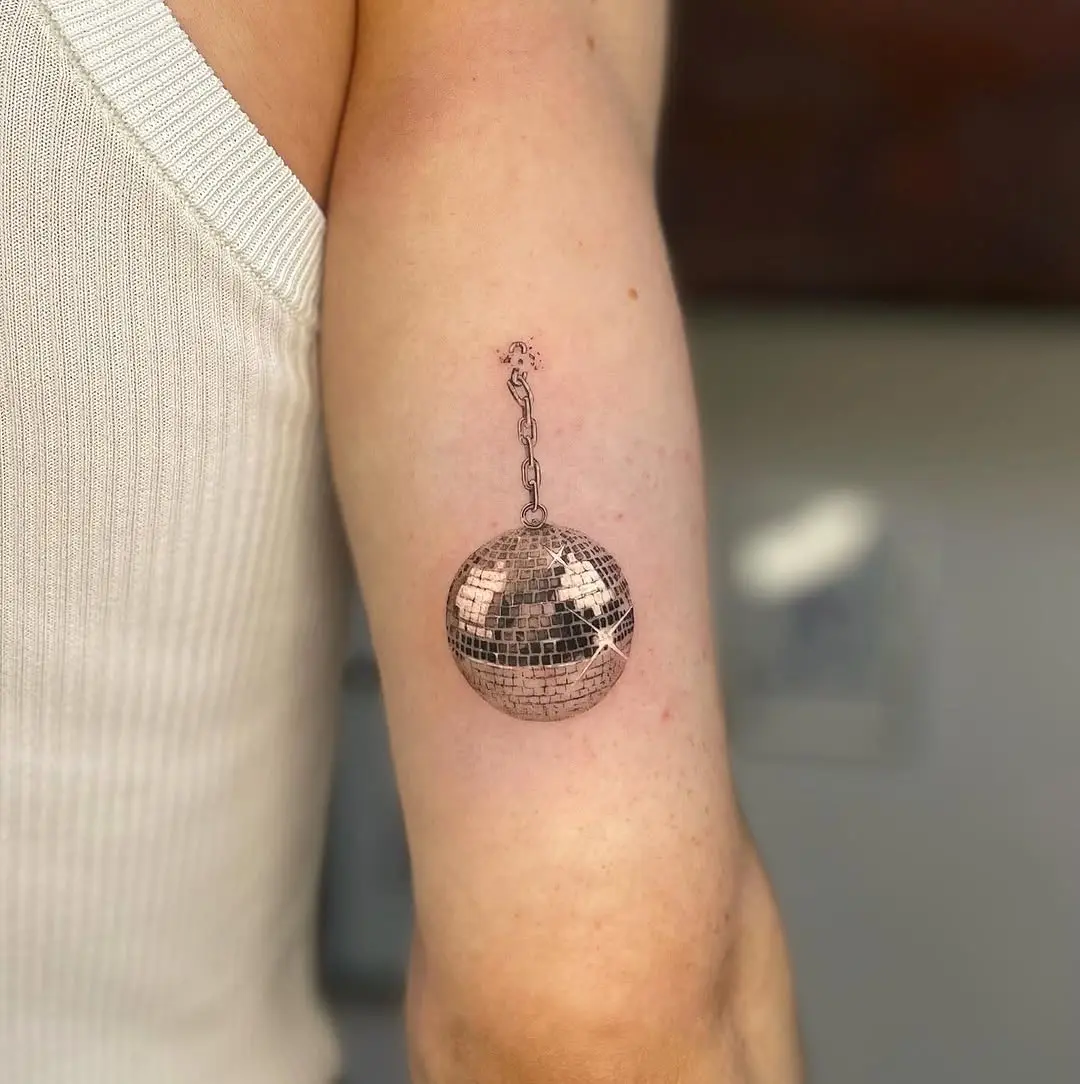 Elegant disco ball tattoo on a trendy arm