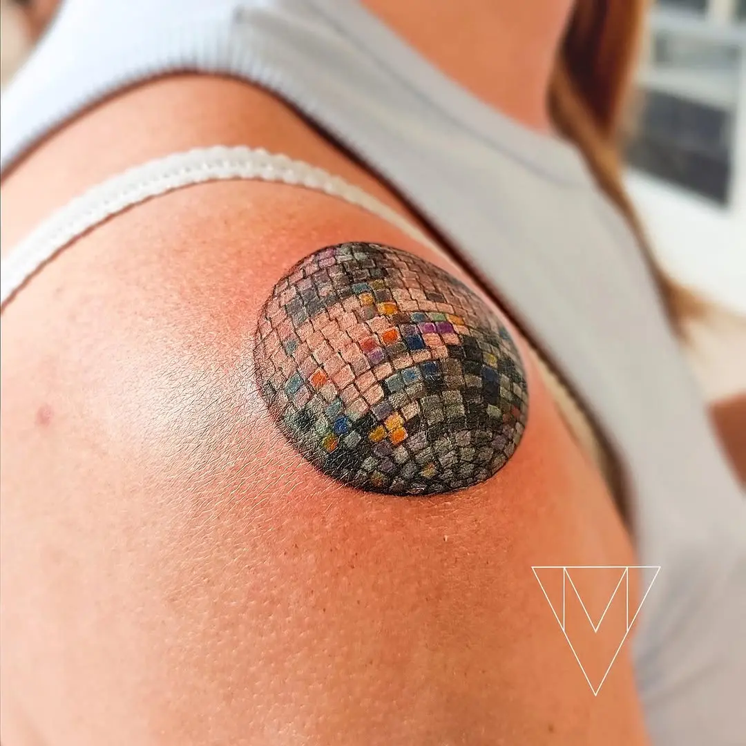 Vibrant disco ball tattoo on shoulder