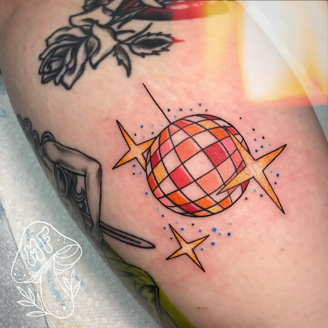 Vibrant disco ball tattoo with playful stars