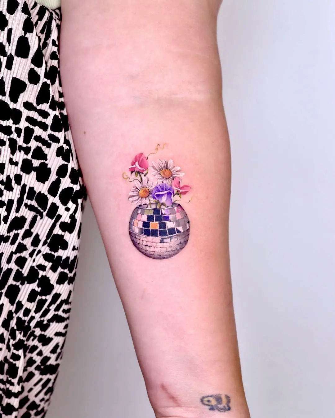 Charming disco ball tattoo with floral details