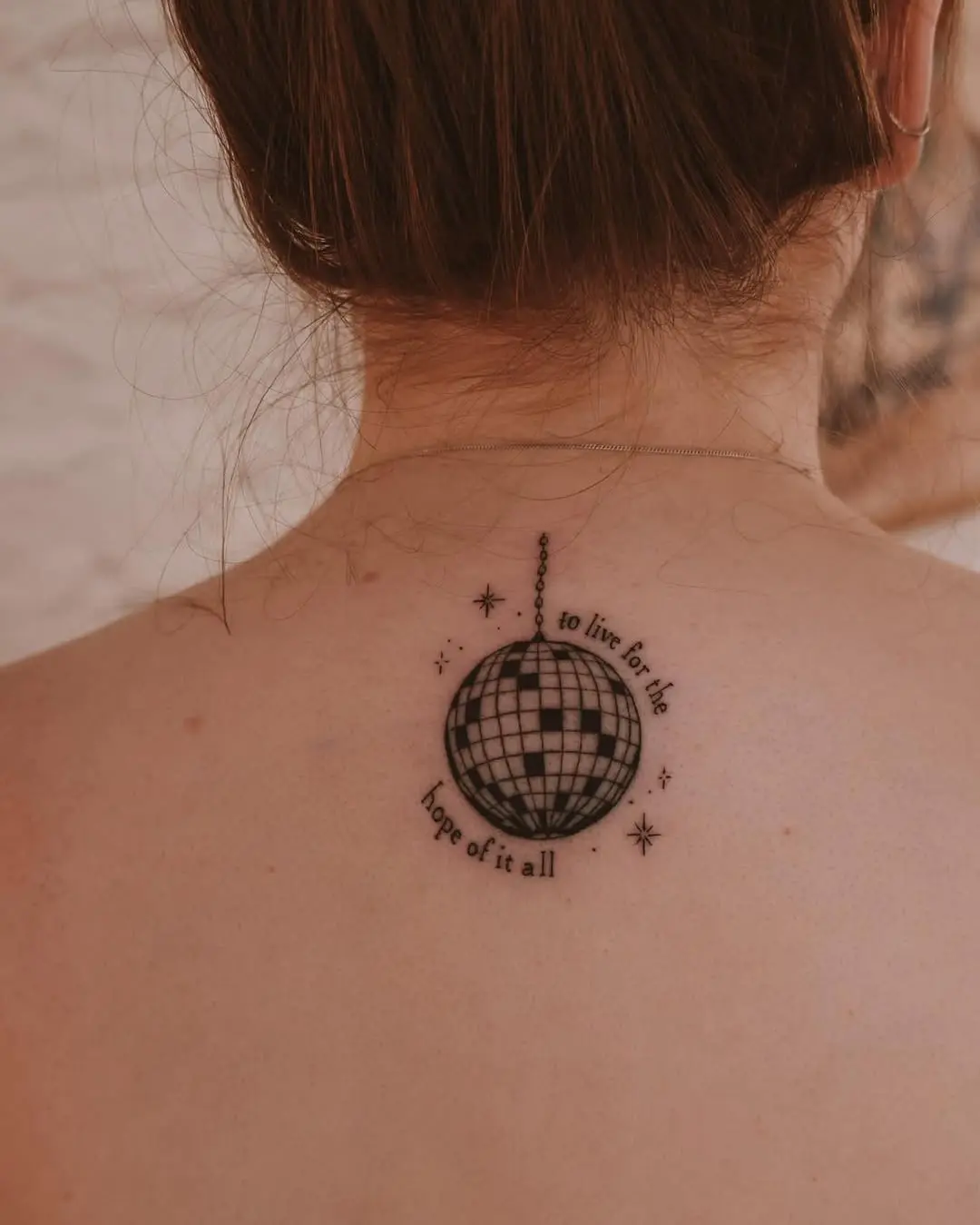 A chic disco ball tattoo with inspiring text