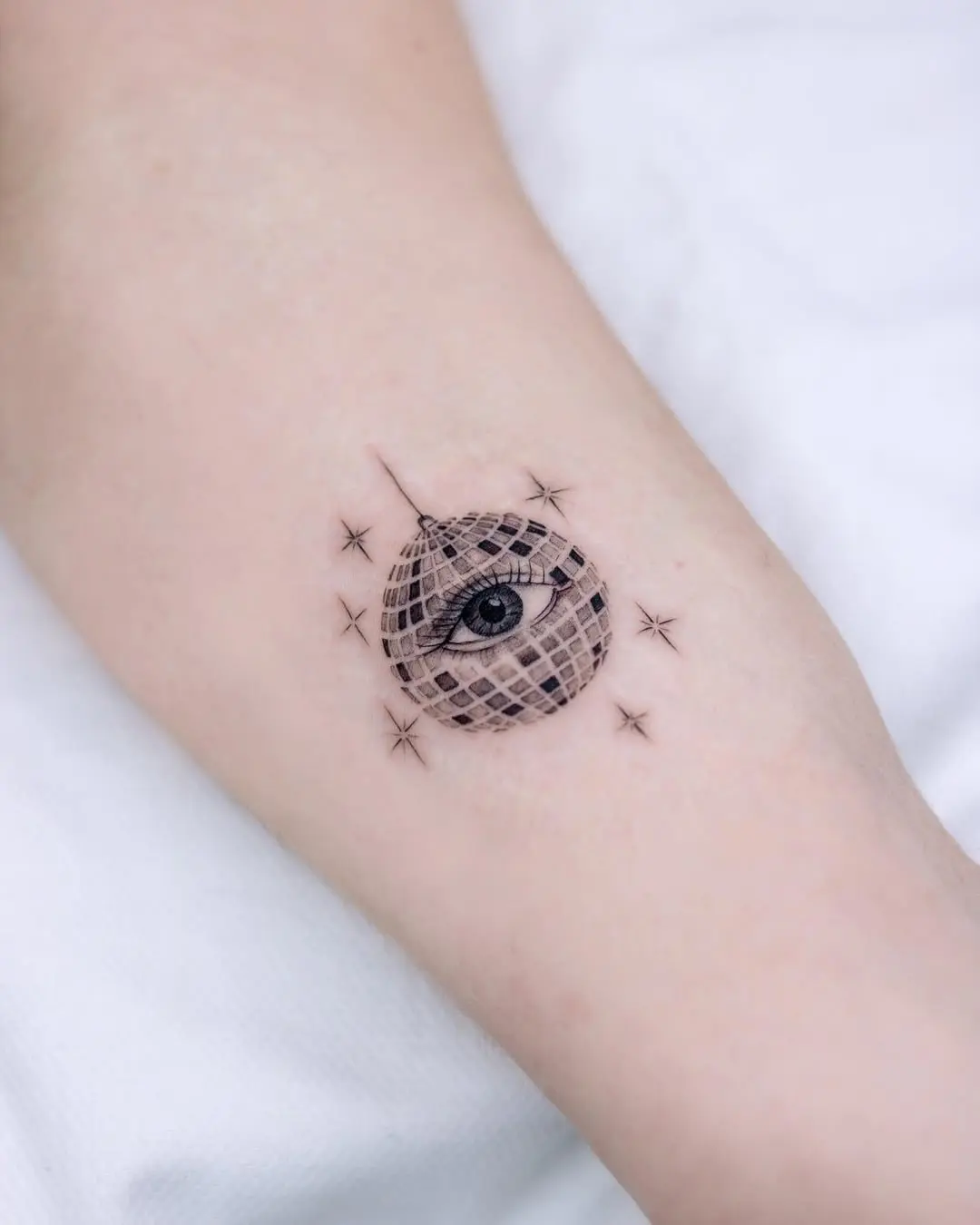 Unique disco ball tattoo with an eye design