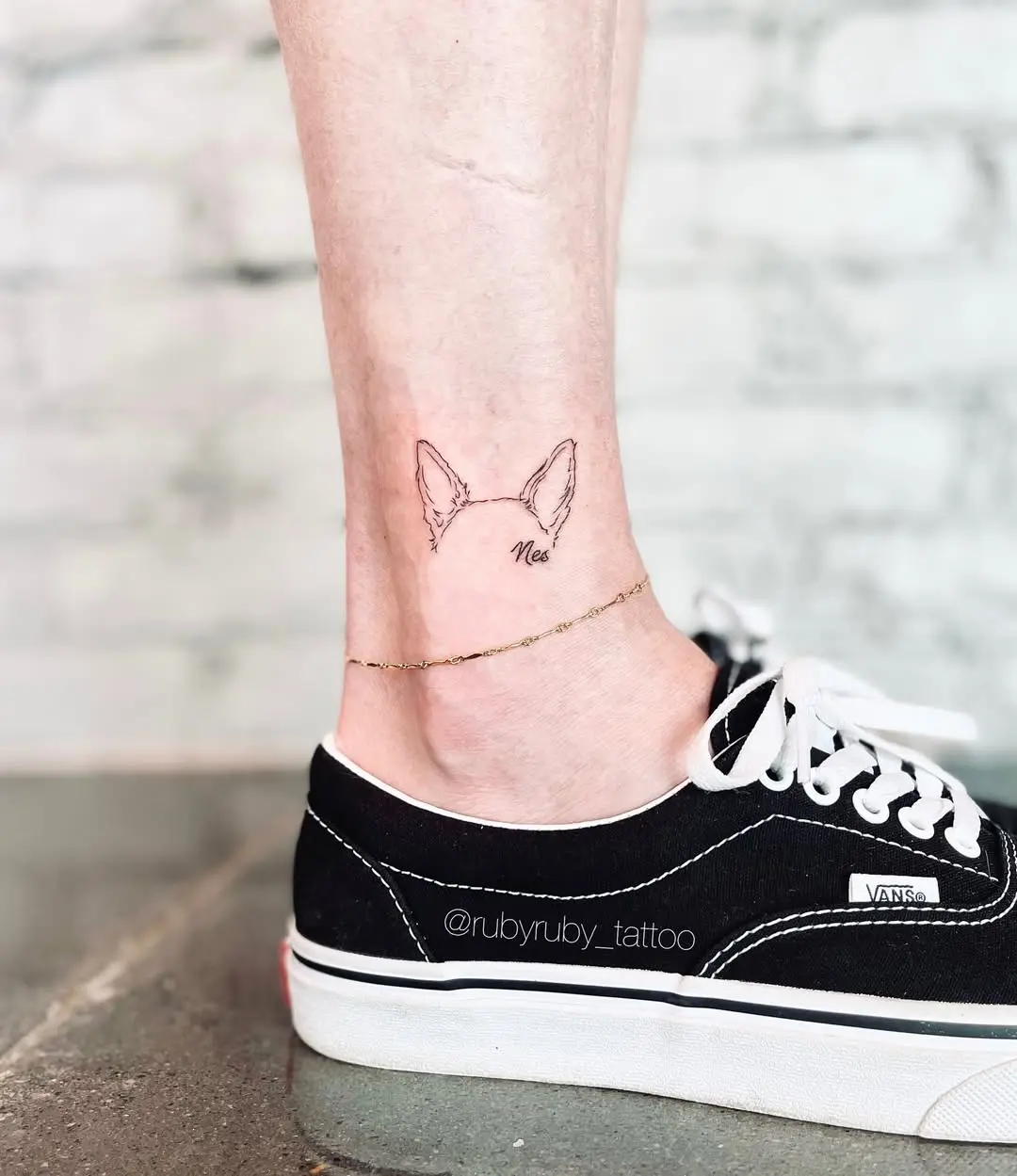 Delicate dog ear tattoo on ankle
