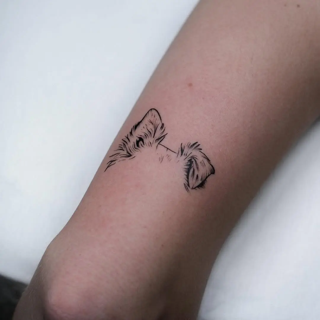 Minimalist dog ear tattoo in black ink