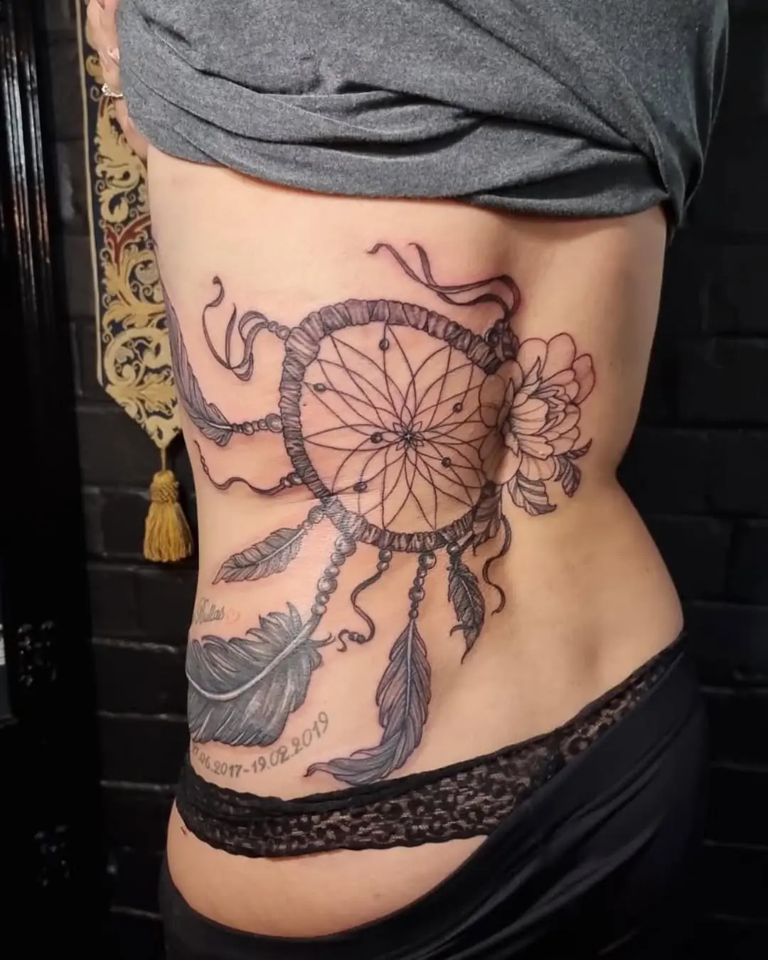 Elegant dreamcatcher tattoo with delicate floral designs