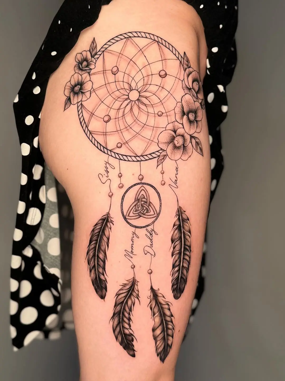 Intricate dreamcatcher tattoo with floral accents