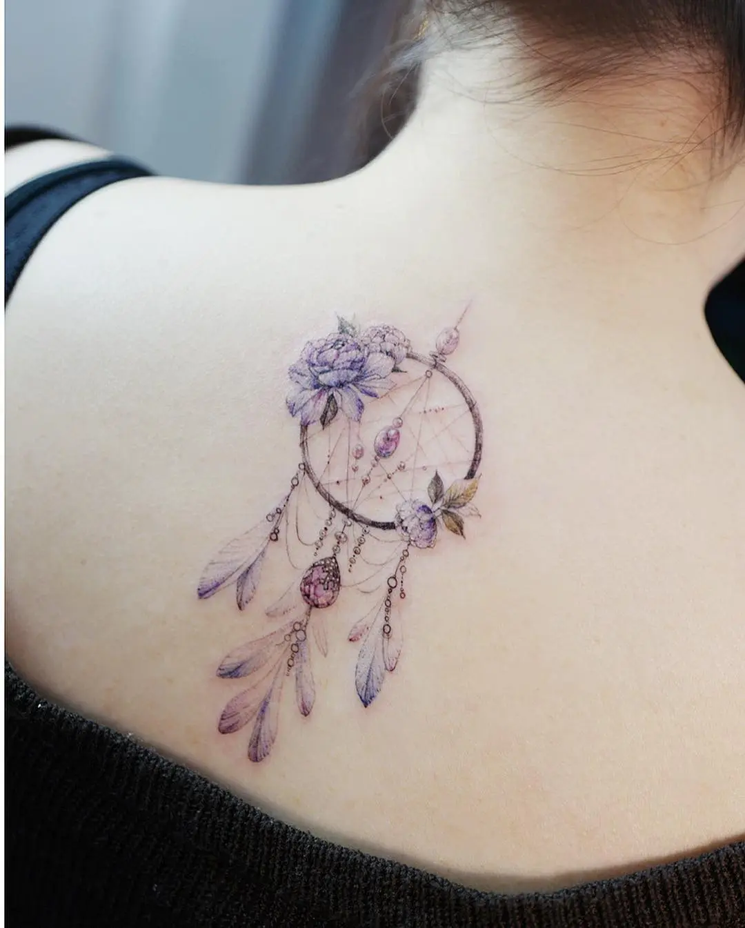 Elegant dreamcatcher tattoo with floral elements