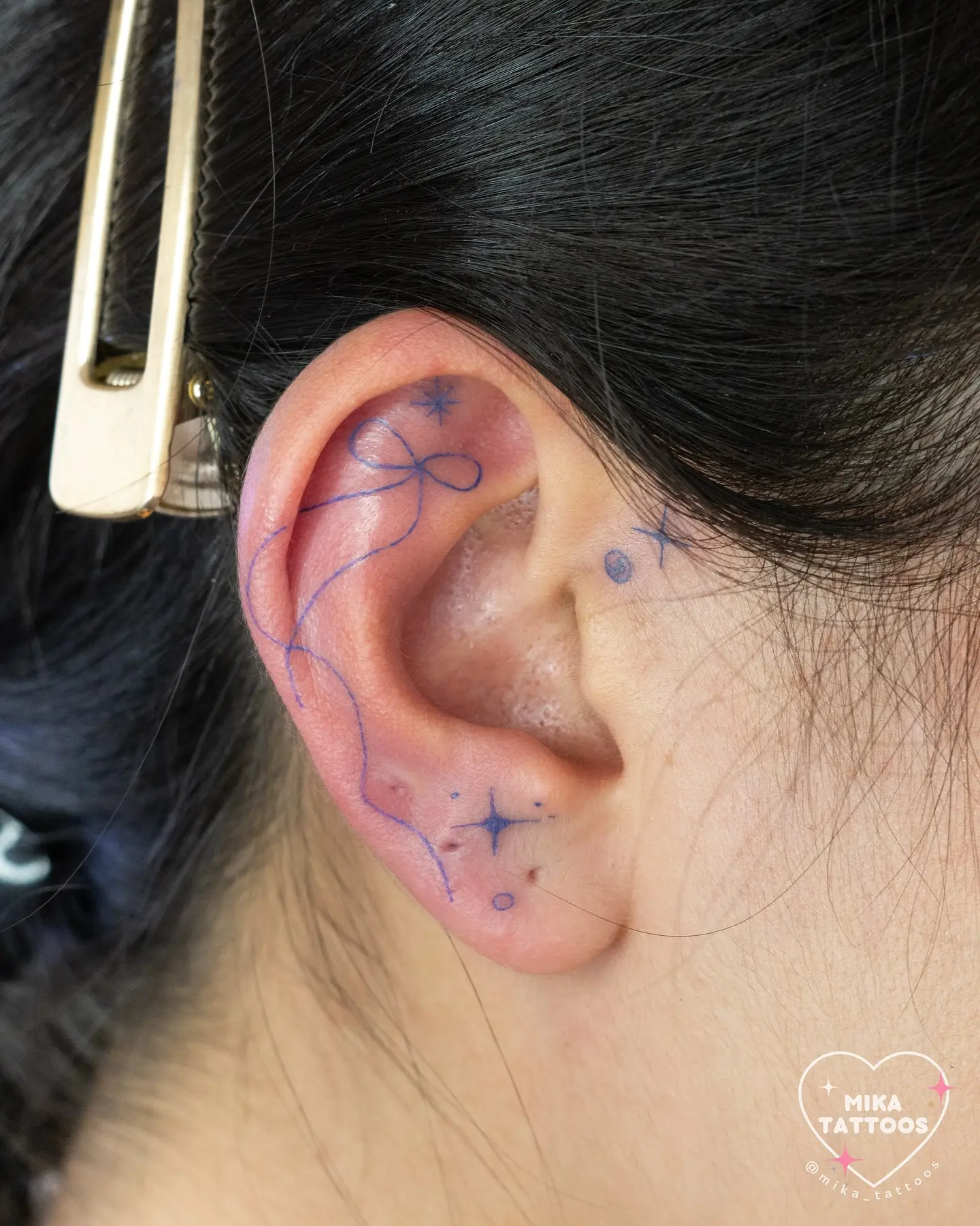 Stylish ear tattoo with minimalist bow design
