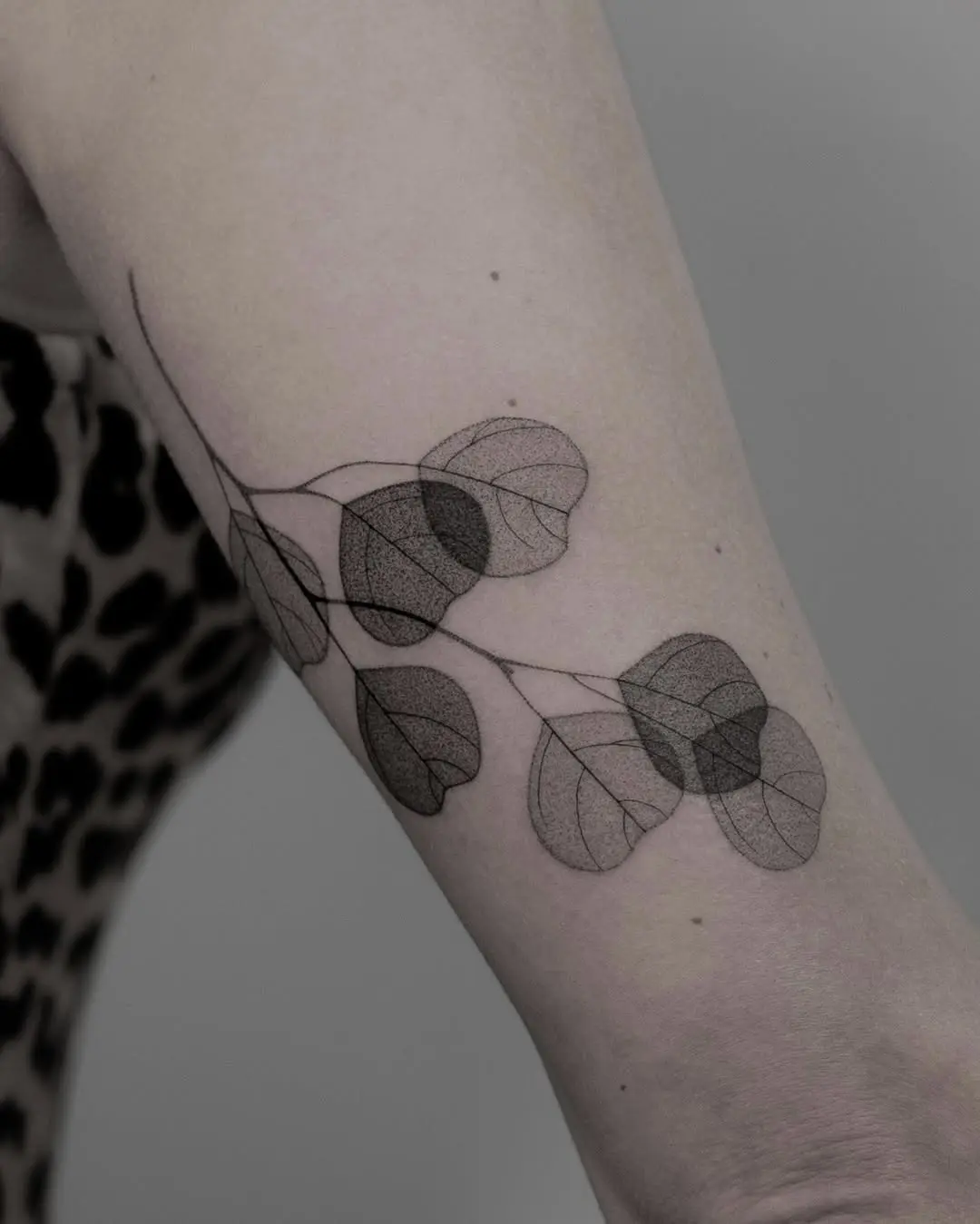 Elegant eucalyptus leaves tattoo on forearm