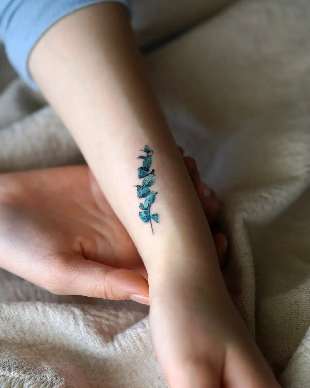 Delicate eucalyptus tattoo on a serene arm