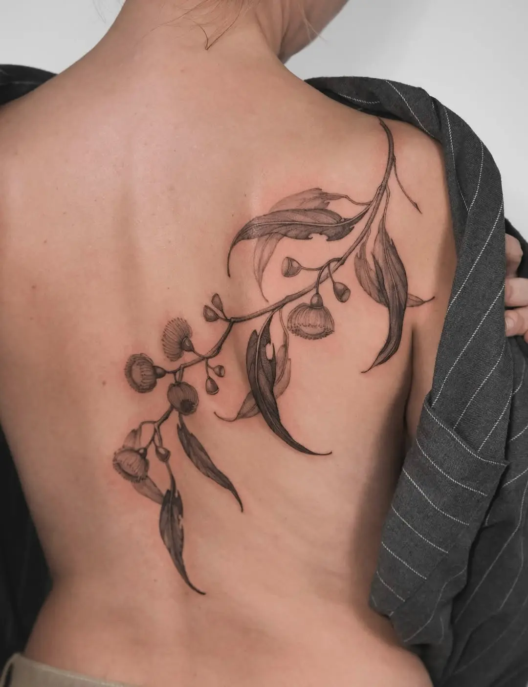 Elegant eucalyptus tattoo enhancing back aesthetics