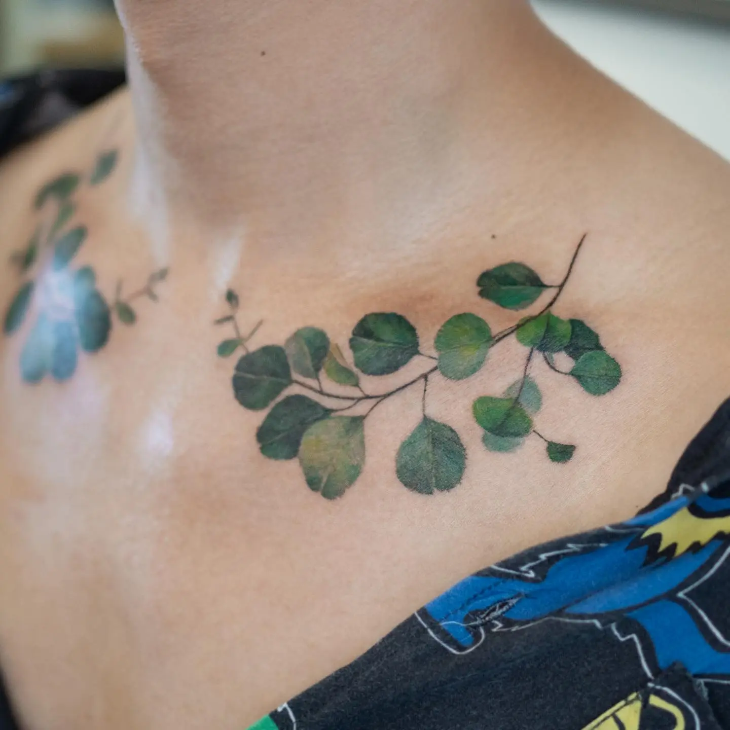 Elegant eucalyptus branch tattoo on collarbone