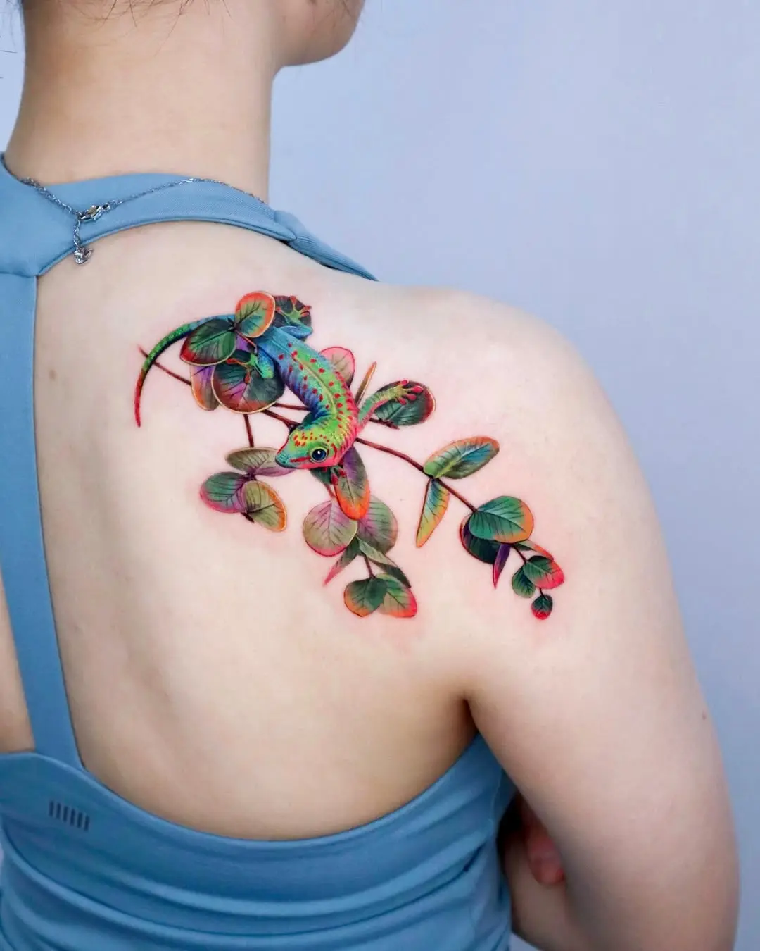 Vibrant eucalyptus tattoo with a lizard design