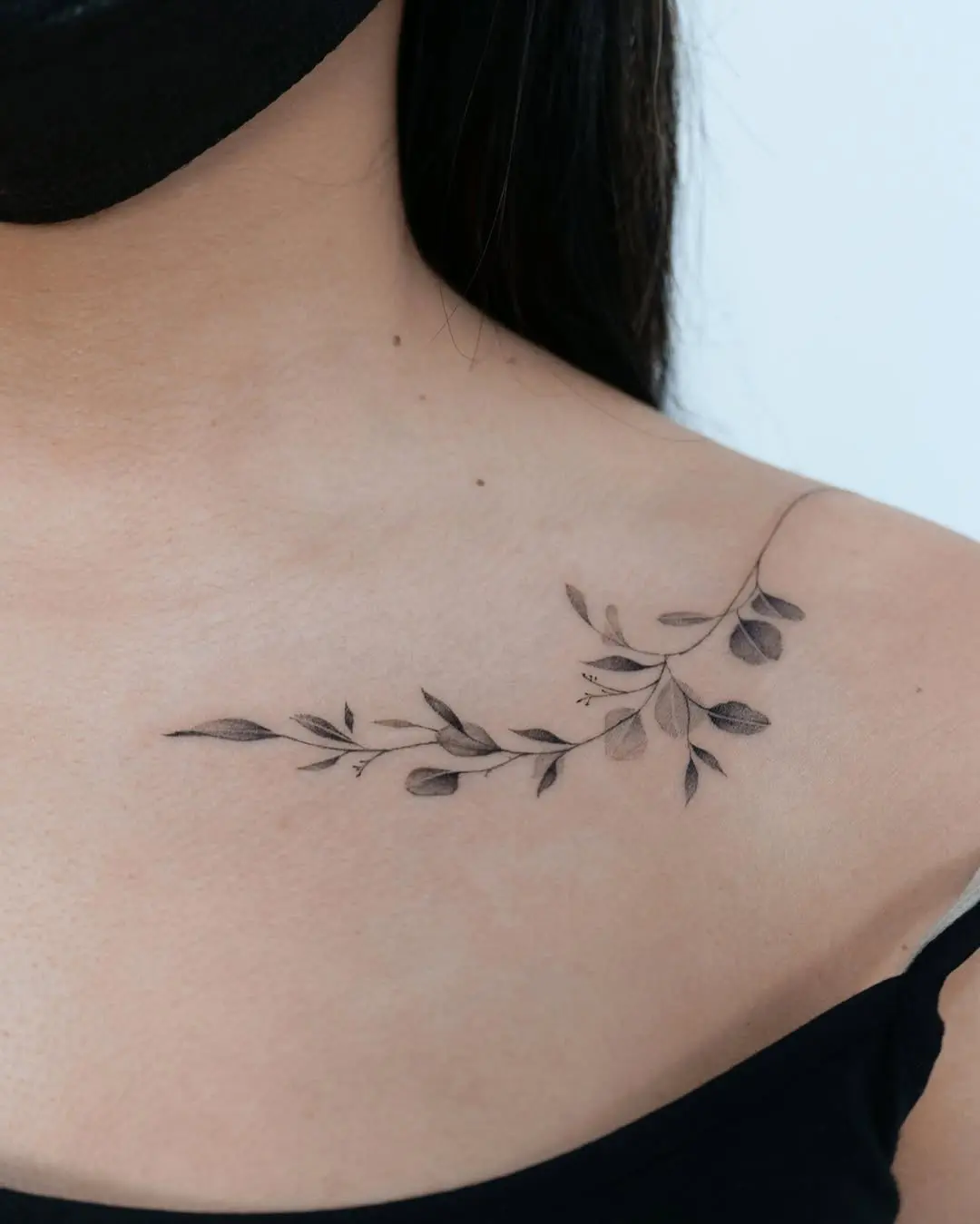 Delicate eucalyptus tattoo on shoulder for a subtle vibe