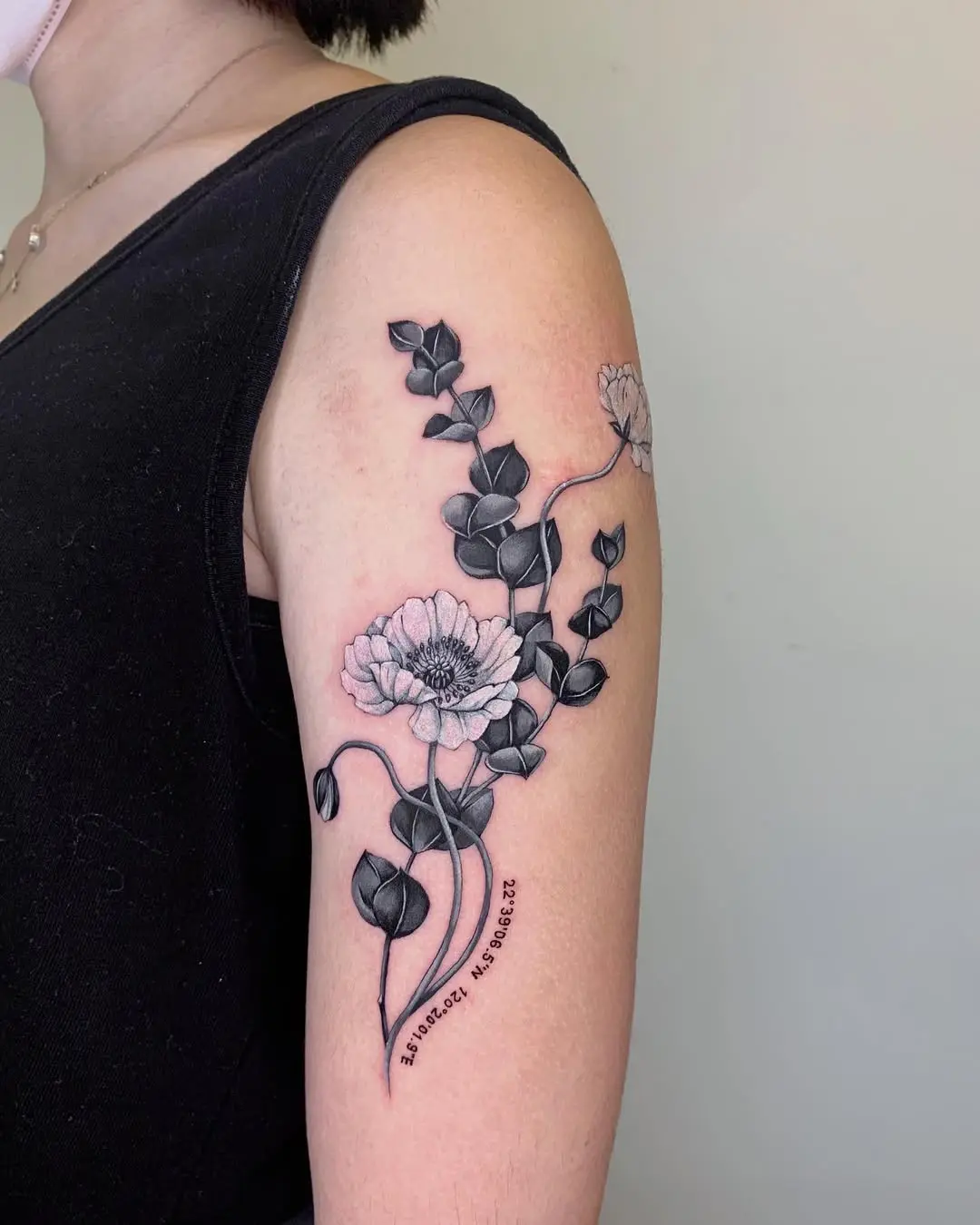 Intricate eucalyptus tattoo with floral accents