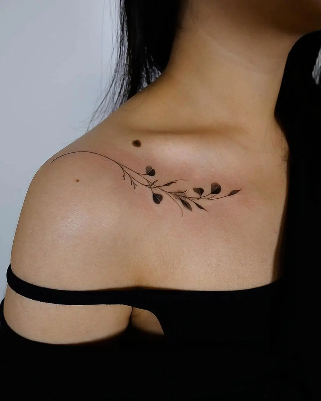 Delicate eucalyptus vine tattoo on shoulder