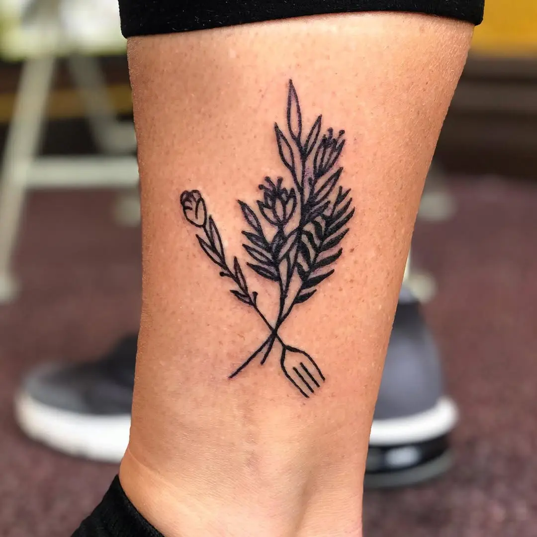 Elegant fork tattoo entwined with delicate flora