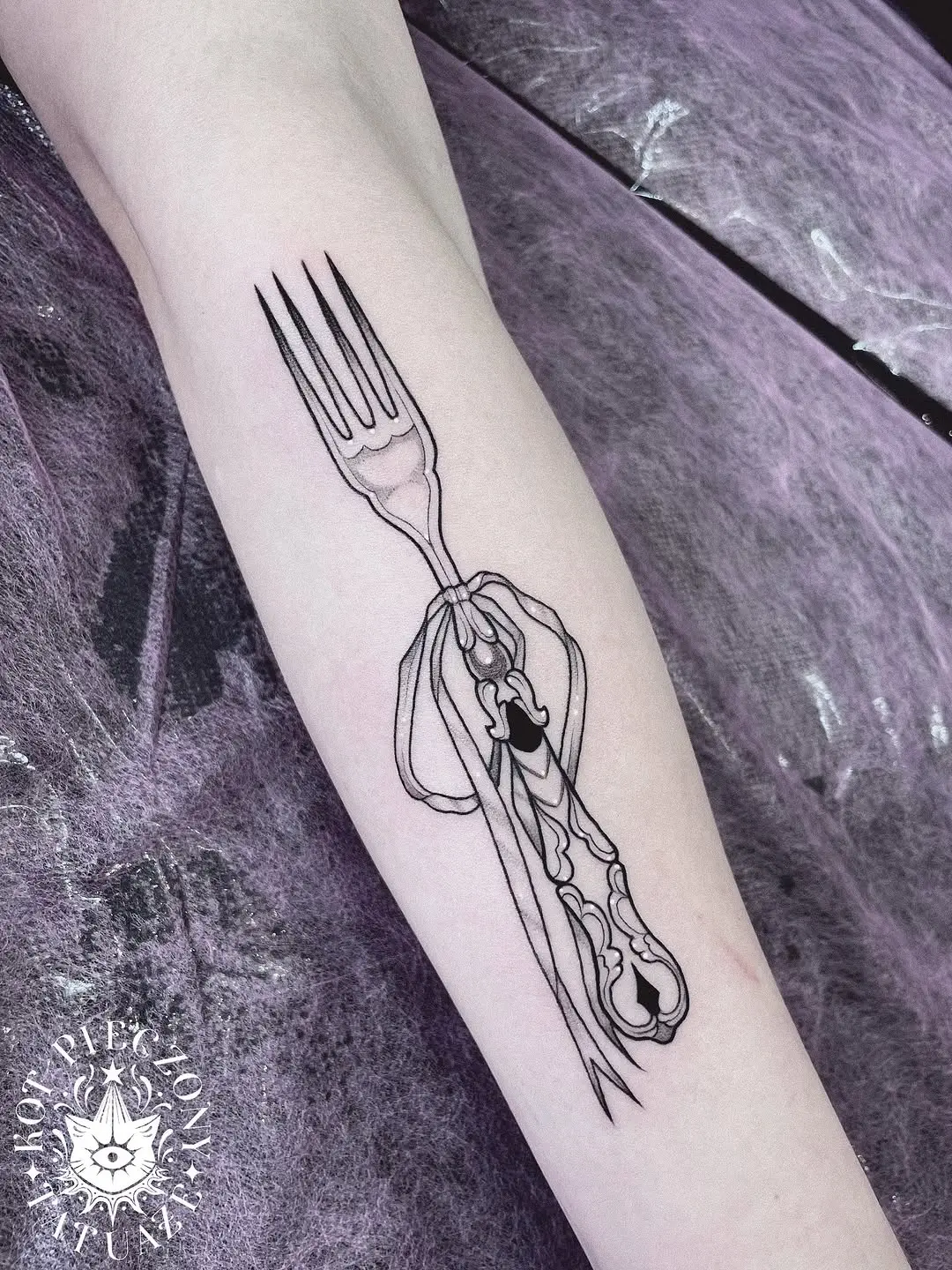 Delicate fork tattoo with elegant ribbon design
