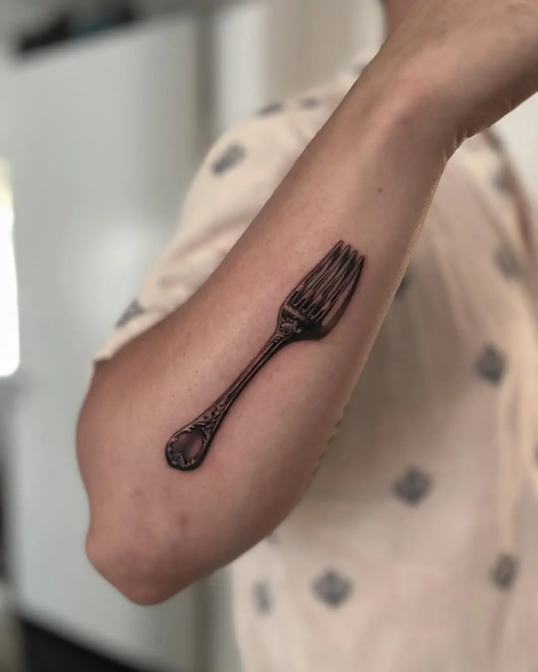 Stylish fork tattoo design on arm.
