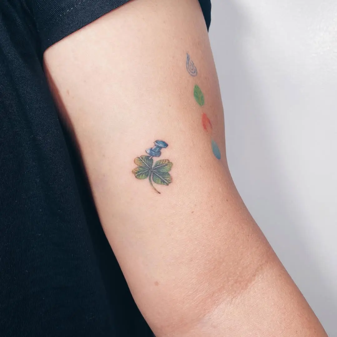 Charming four leaf clover tattoo with a bird