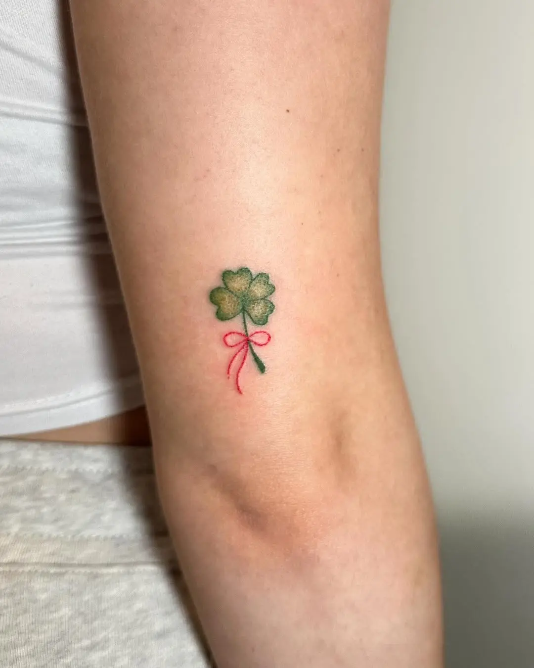 Charming four leaf clover tattoo with pink ribbon