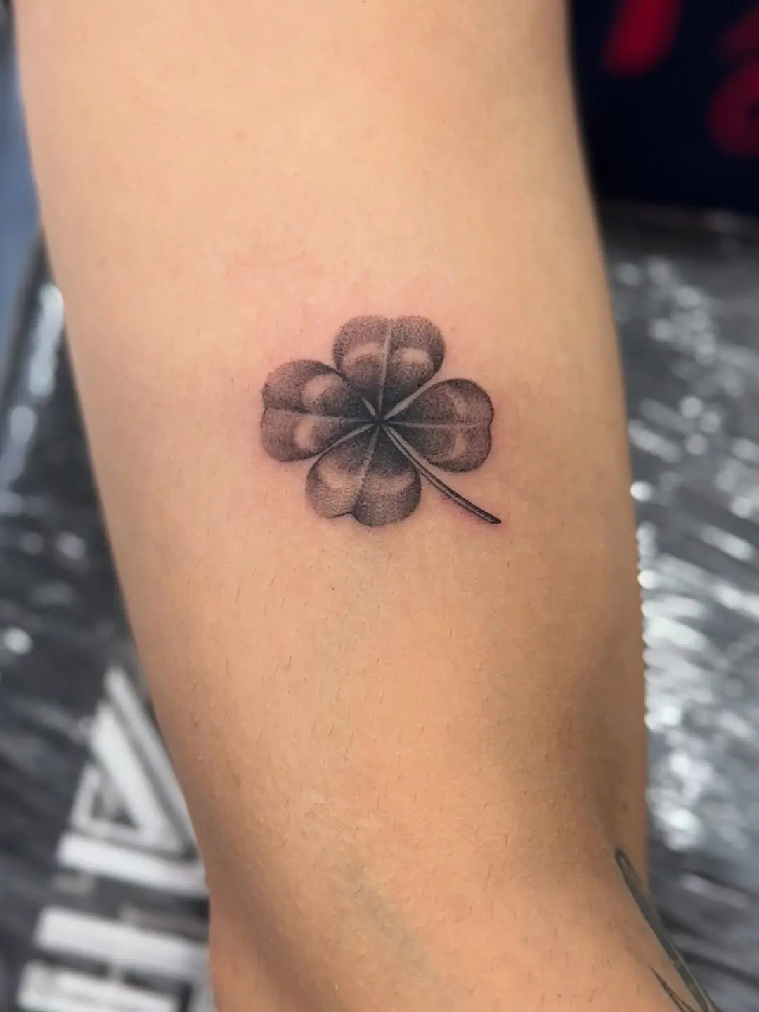 Realistic four leaf clover tattoo in black ink