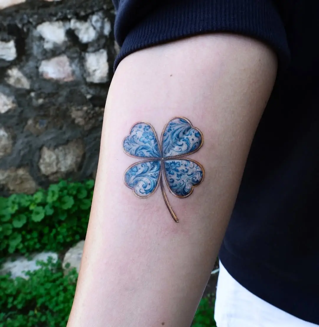 Elegant blue four-leaf clover tattoo design