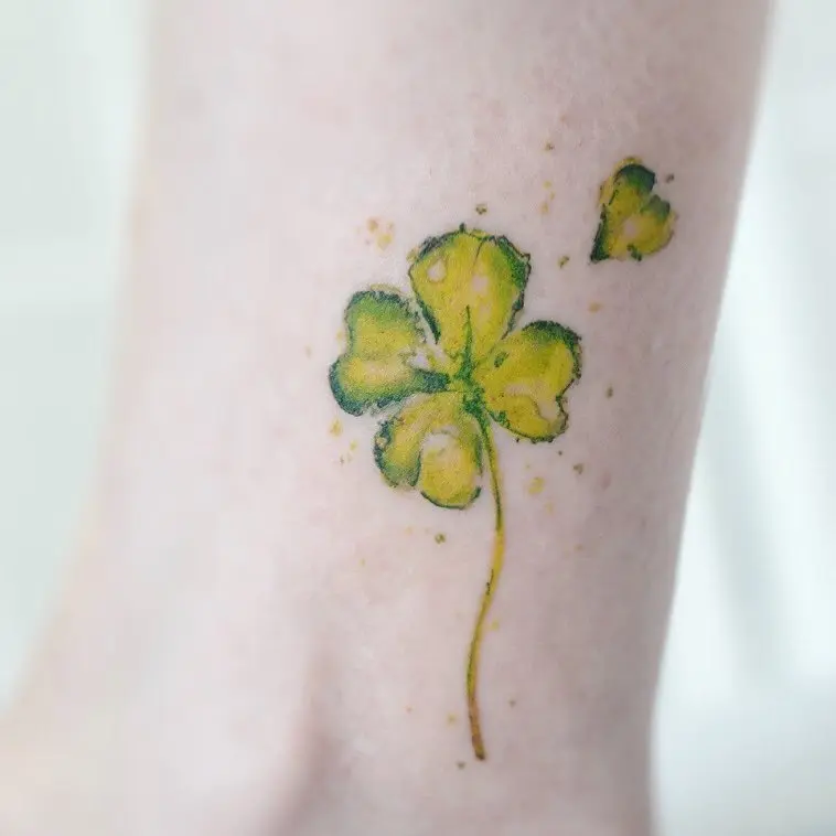 Vibrant watercolor four-leaf clover tattoo design