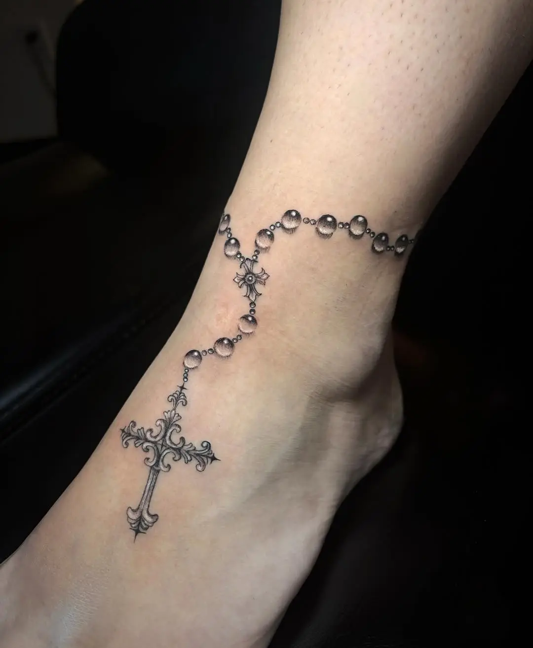 Elegant ankle rosary tattoo with cross design