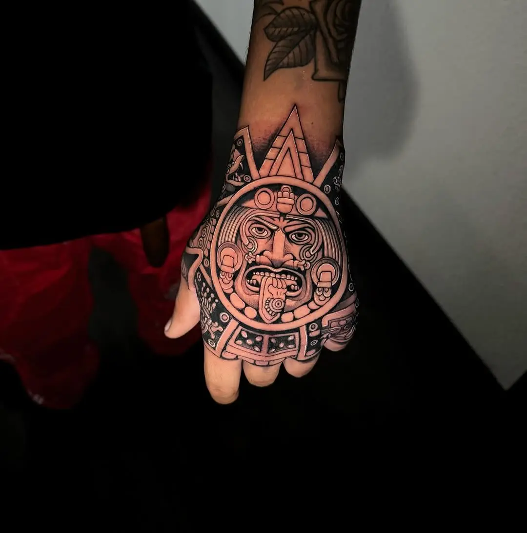 Intricate Aztec god tattoo on hand