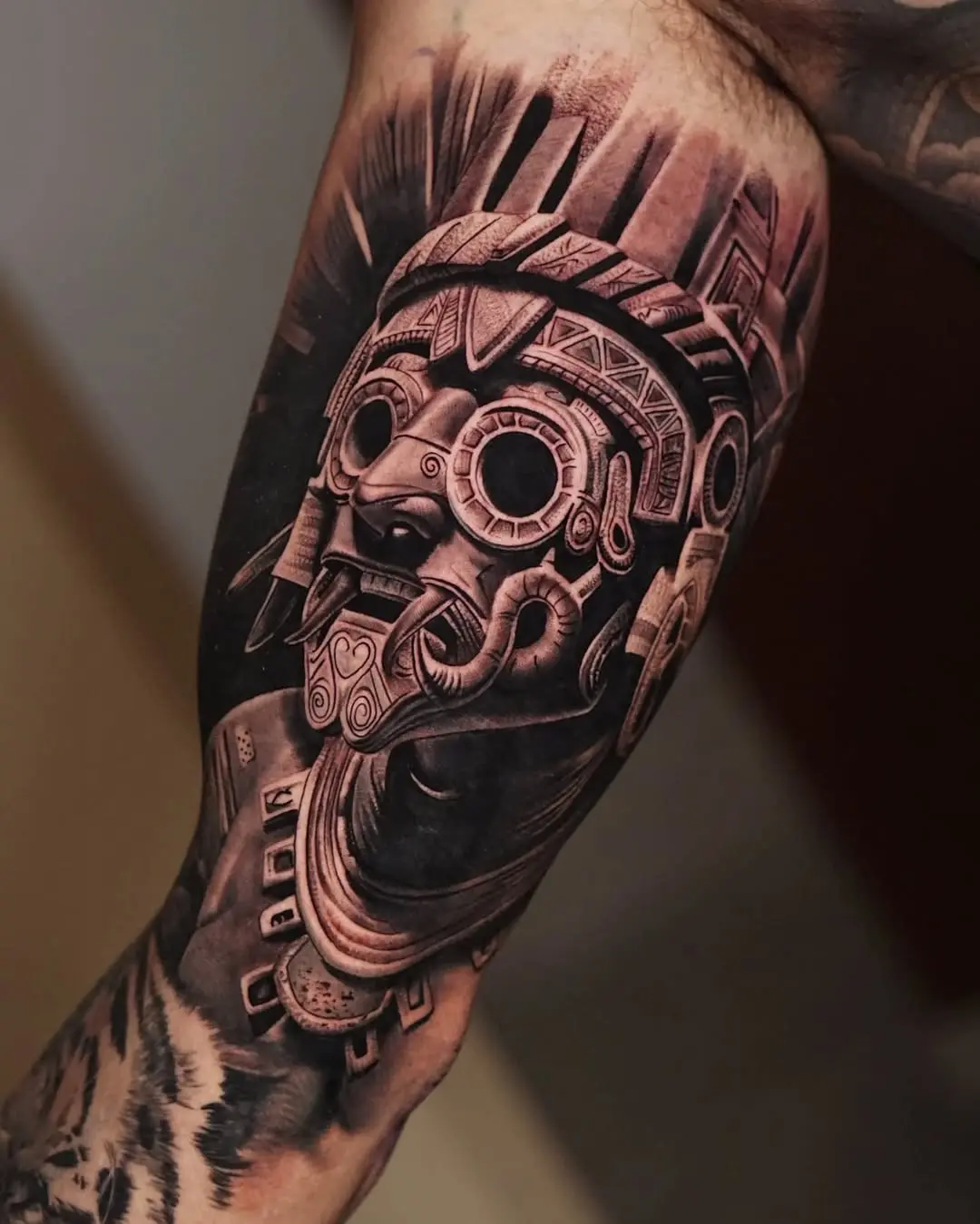 Intricate Aztec statue tattoo on forearm