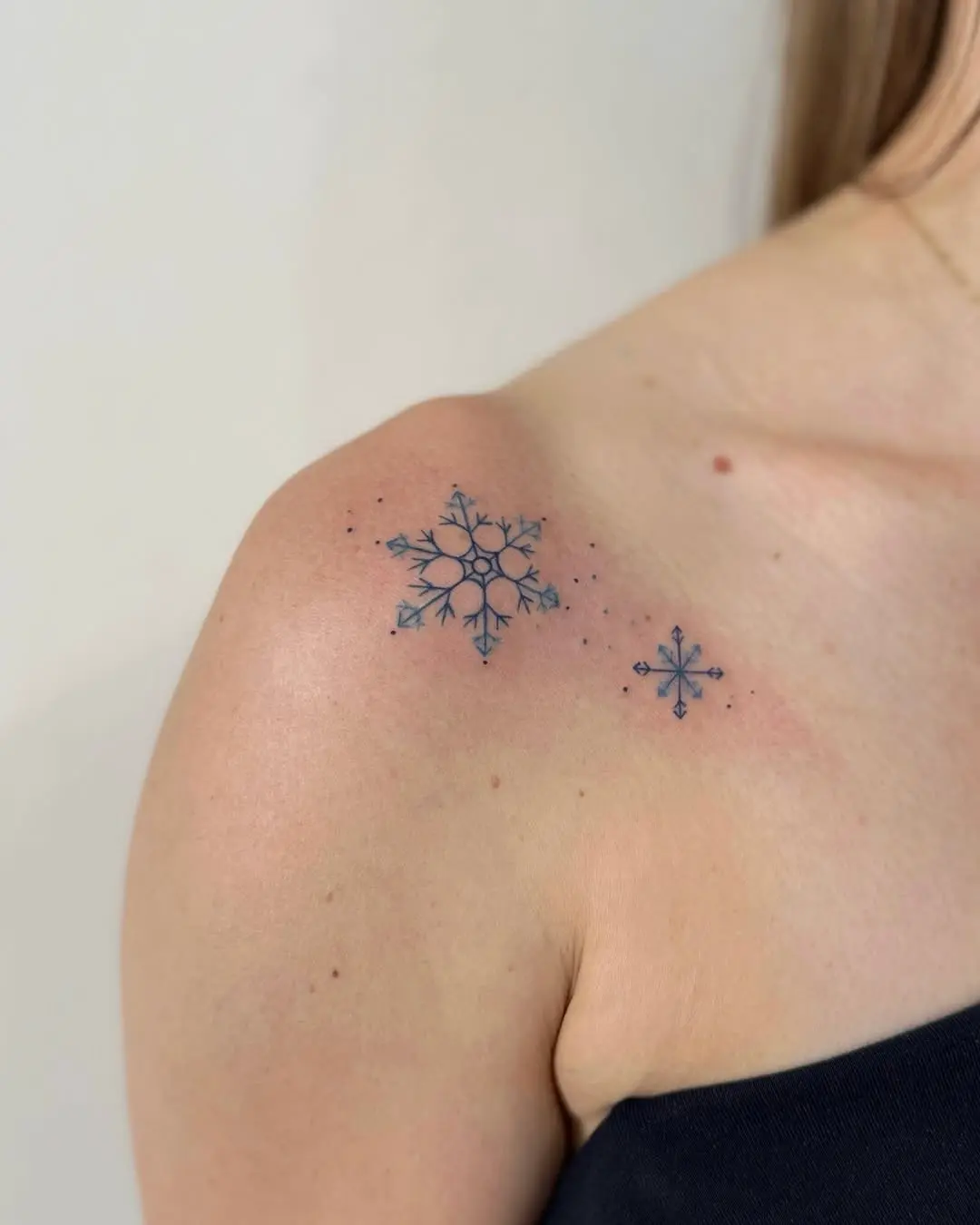 Delicate snowflake tattoos adorned on shoulder