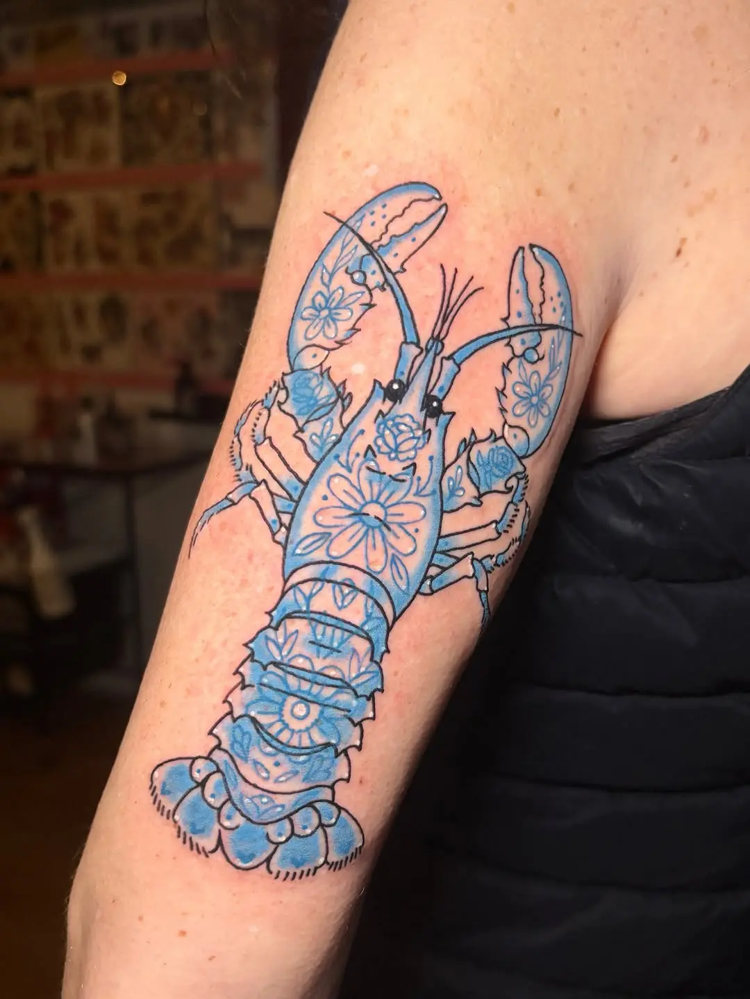 Elegant lobster tattoo with floral accents