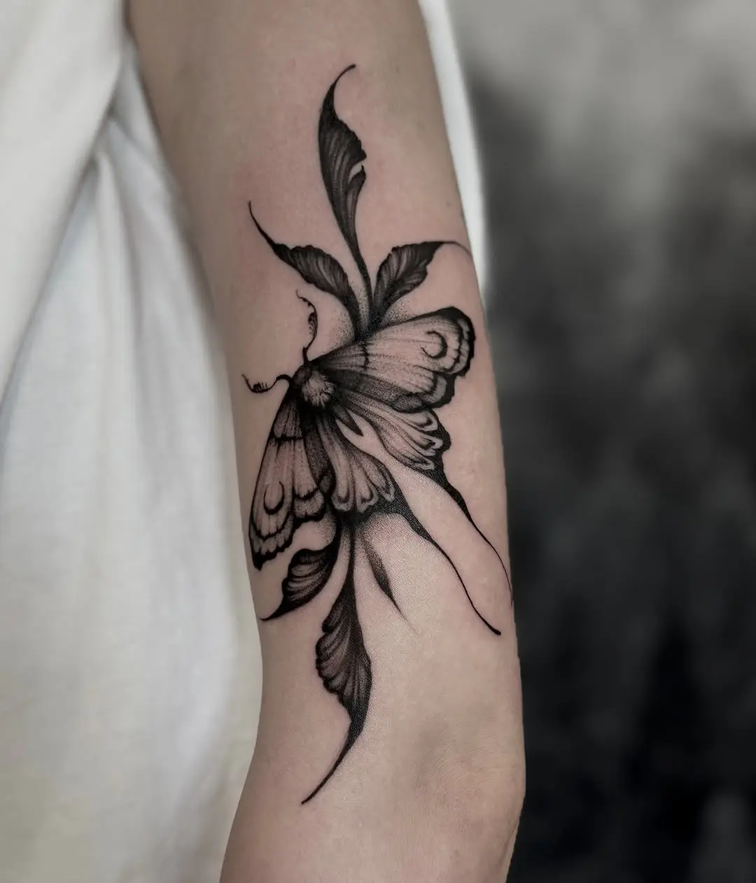 Elegant butterfly dotwork tattoo with floral elements