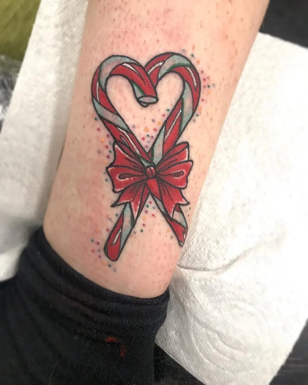 Charming heart-shaped candy cane tattoo design