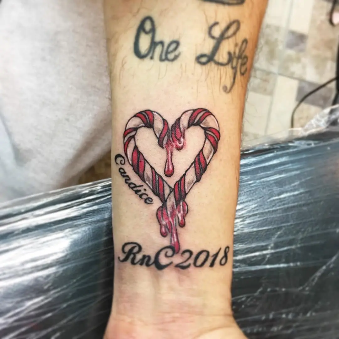 Whimsical candy cane heart tattoo design