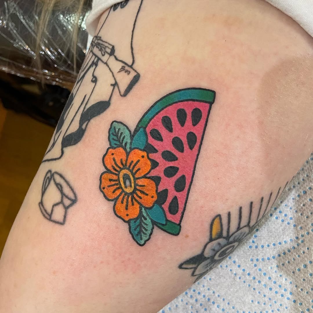 Vibrant watermelon tattoo with floral accents