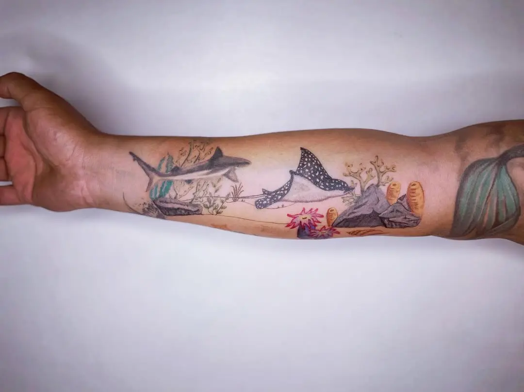 Vibrant coral reef tattoo with sharks and beauty