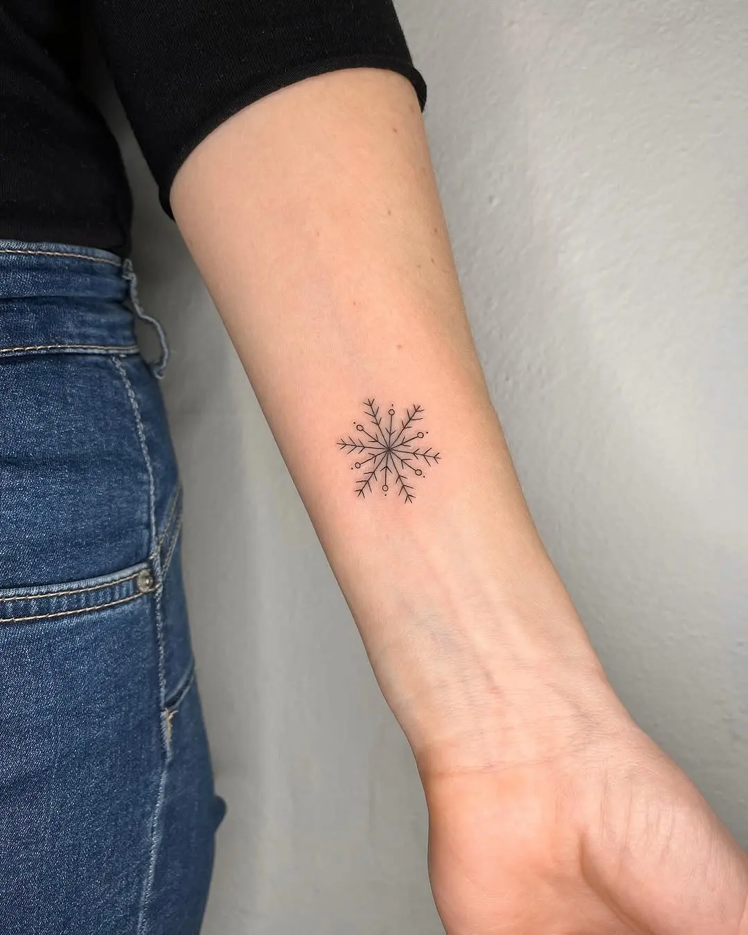 Minimalist snowflake tattoo with intricate details