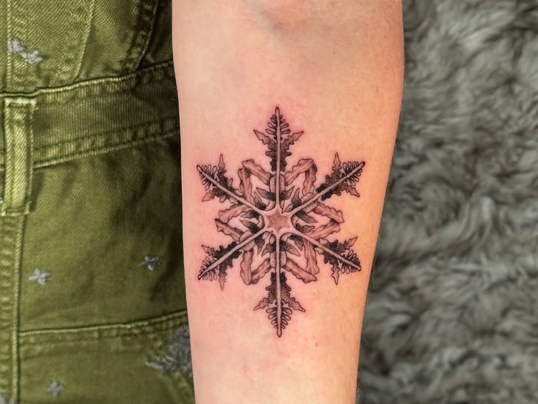 Intricate snowflake tattoo with delicate details