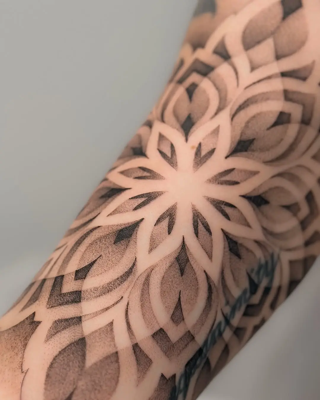 Intricate dotwork floral tattoo design on arm