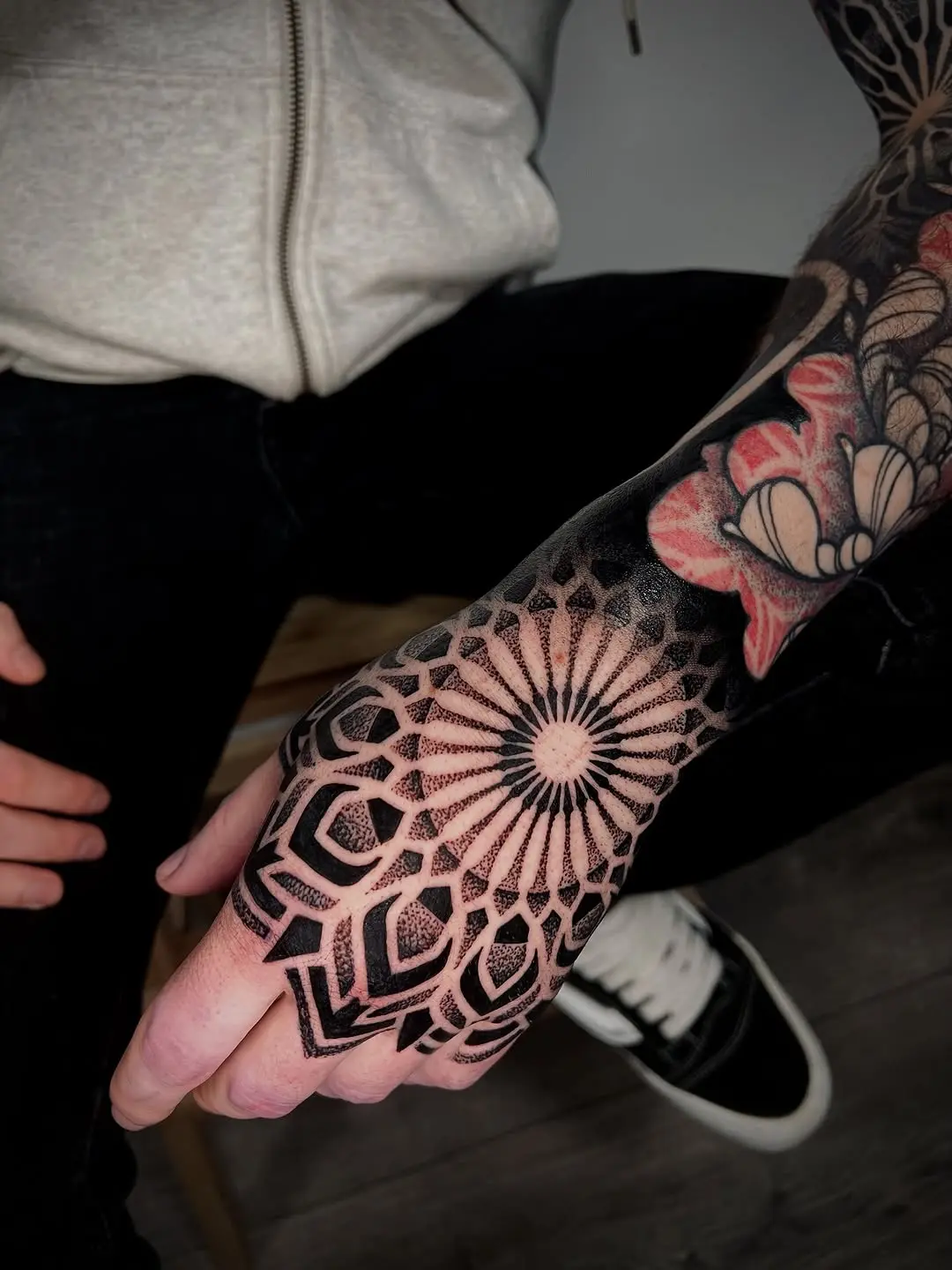 Intricate dotwork hand tattoo with geometric patterns