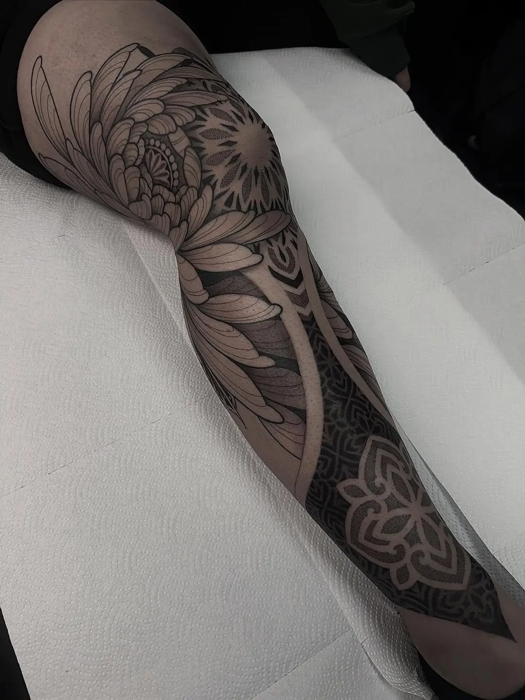 Intricate floral dotwork tattoo on leg