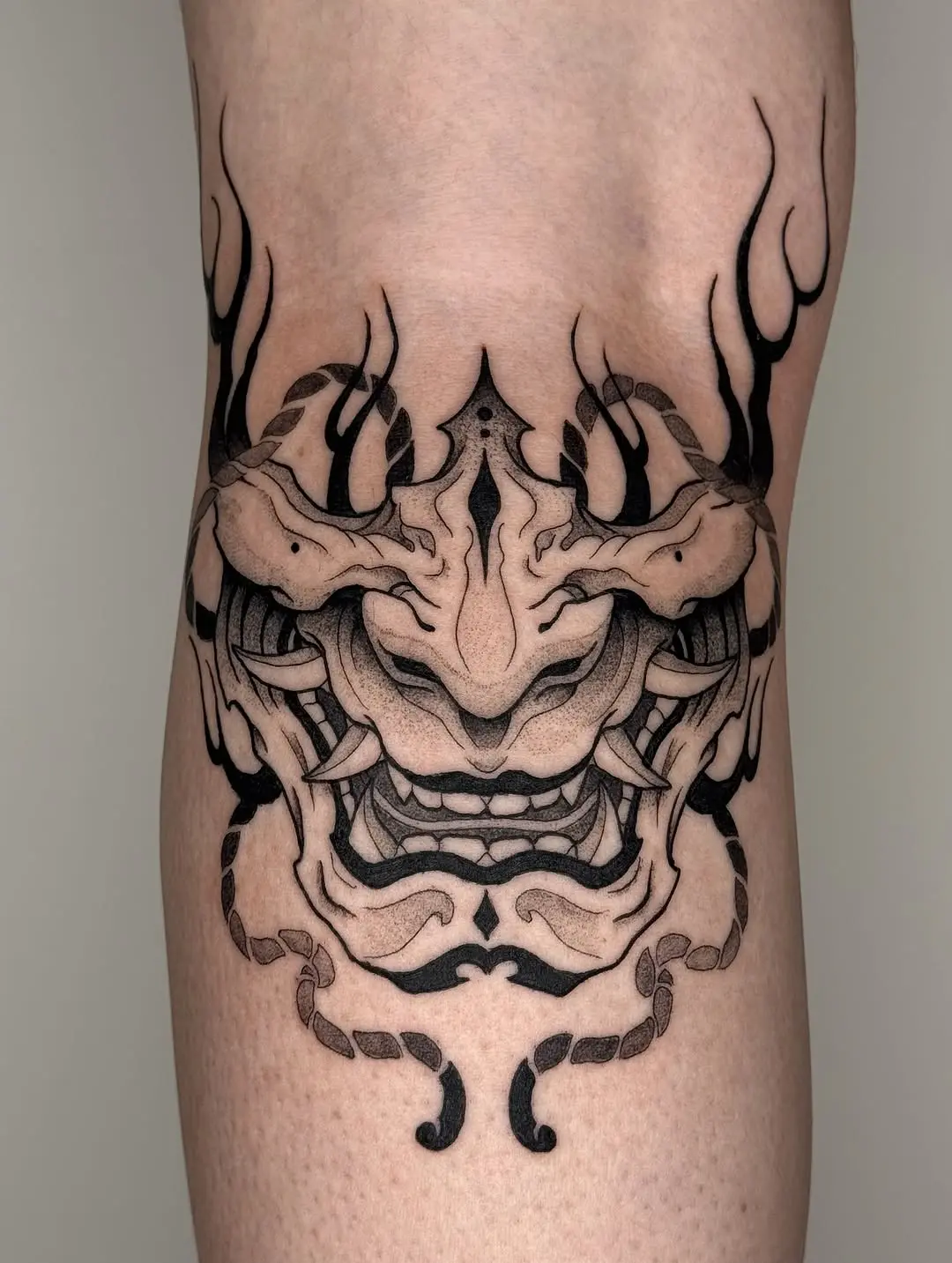 Intricate dotwork tattoo of a mythical mask