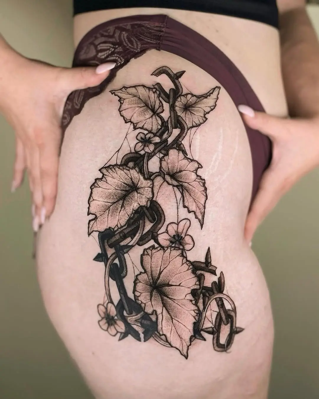 Stunning begonia tattoo wrapped around the thigh