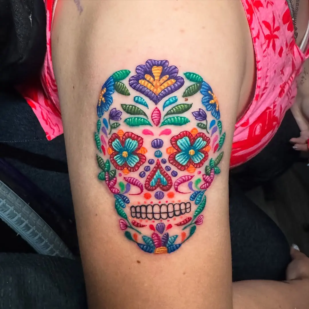 Vibrant sugar skull tattoo with floral embroidery